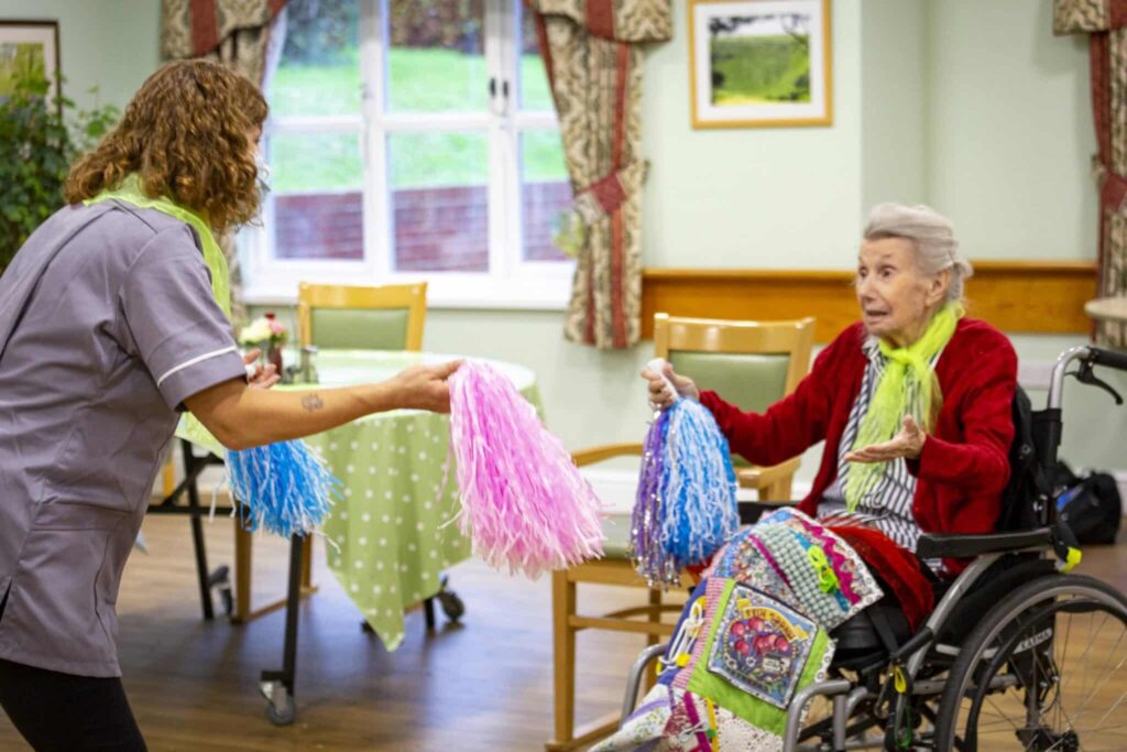 Resident and Staff Using Pom Poms