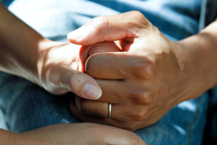 carer and resident holding hands