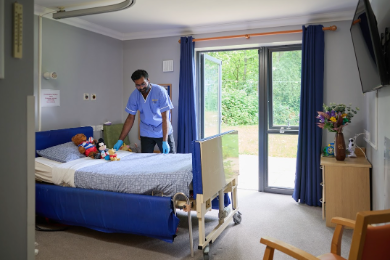 care home nurse tidying bedroom